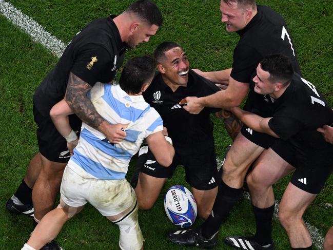 New Zealand's scrum-half Aaron Smith (C) celebrates with teammates after scoring a try during the France 2023 Rugby World Cup semi-final match between Argentina and New Zealand at the Stade de France in Saint-Denis, on the outskirts of Paris, on October 20, 2023. (Photo by Miguel MEDINA / AFP)