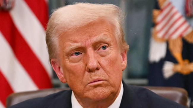 US President Donald Trump signs an executive order for pardons on January 6 offenders in the Oval Office of the WHite House in Washington, DC, on January 20, 2025. (Photo by Jim WATSON / POOL / AFP)