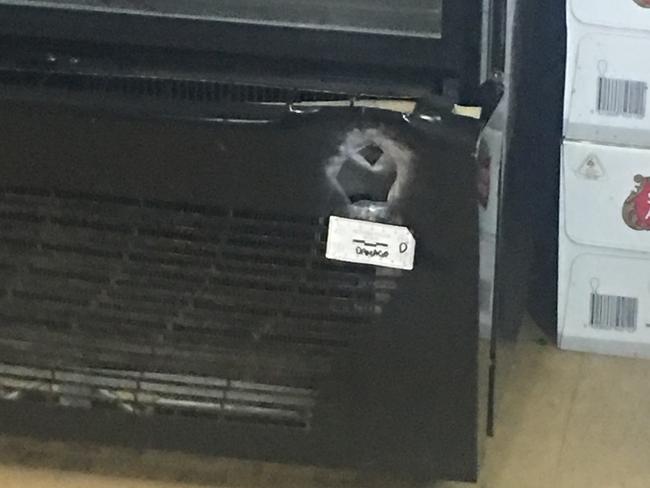A bullet hole marks the bottom of fridge in the Park Orchards store.