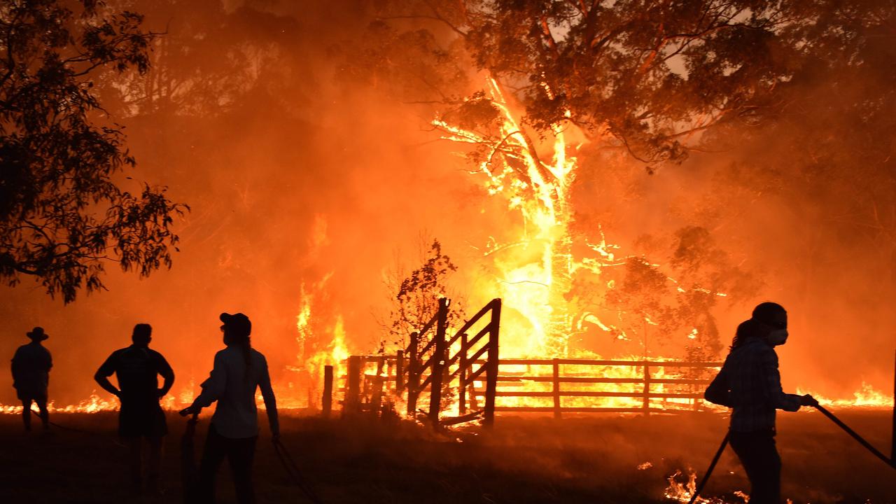 Residents defend a property from a bushfire at Hillville, near Taree. Picture: AFP