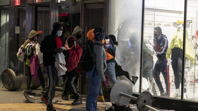 Looters seen raiding the Champs store in Manhattan, New York.