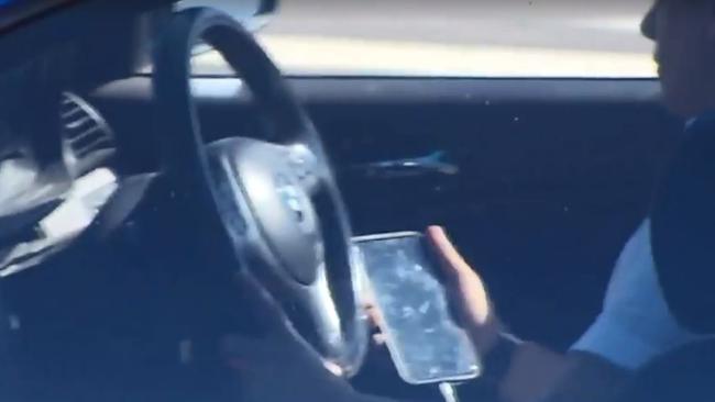 Mobile in his hand, this driver is distracted by what’s going on his screen while driving on the road.