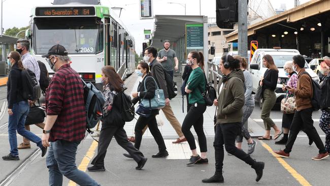 Workers crossing Swanston St on Monday. Picture: David Crosling