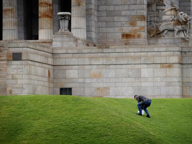 An ex-serviceman cleans up rubbish at the Shrine of Remembrance left behind by protesters. Picture: Andrew Henshaw