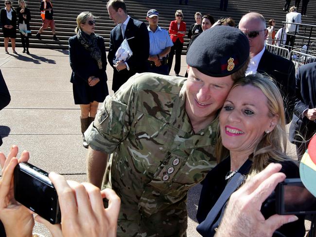 An admirer grabs a quick photo op with the prince. Picture: Stephen Cooper