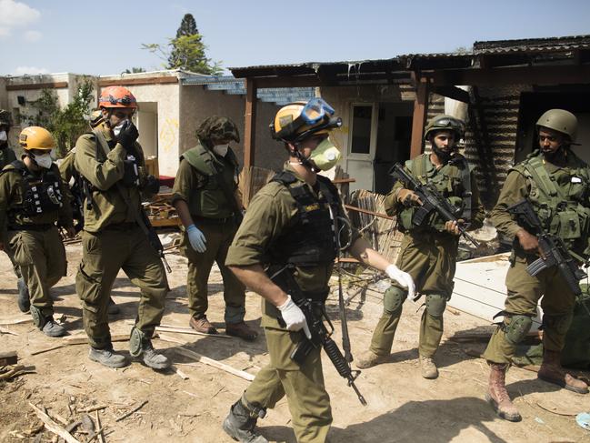 Israeli soldiers patrol near burned and destroyed houses after an attack by Palestinian militants on this kibbutz near the border with Gaza in Kfar Gaza, Israel. Picture: Getty Images