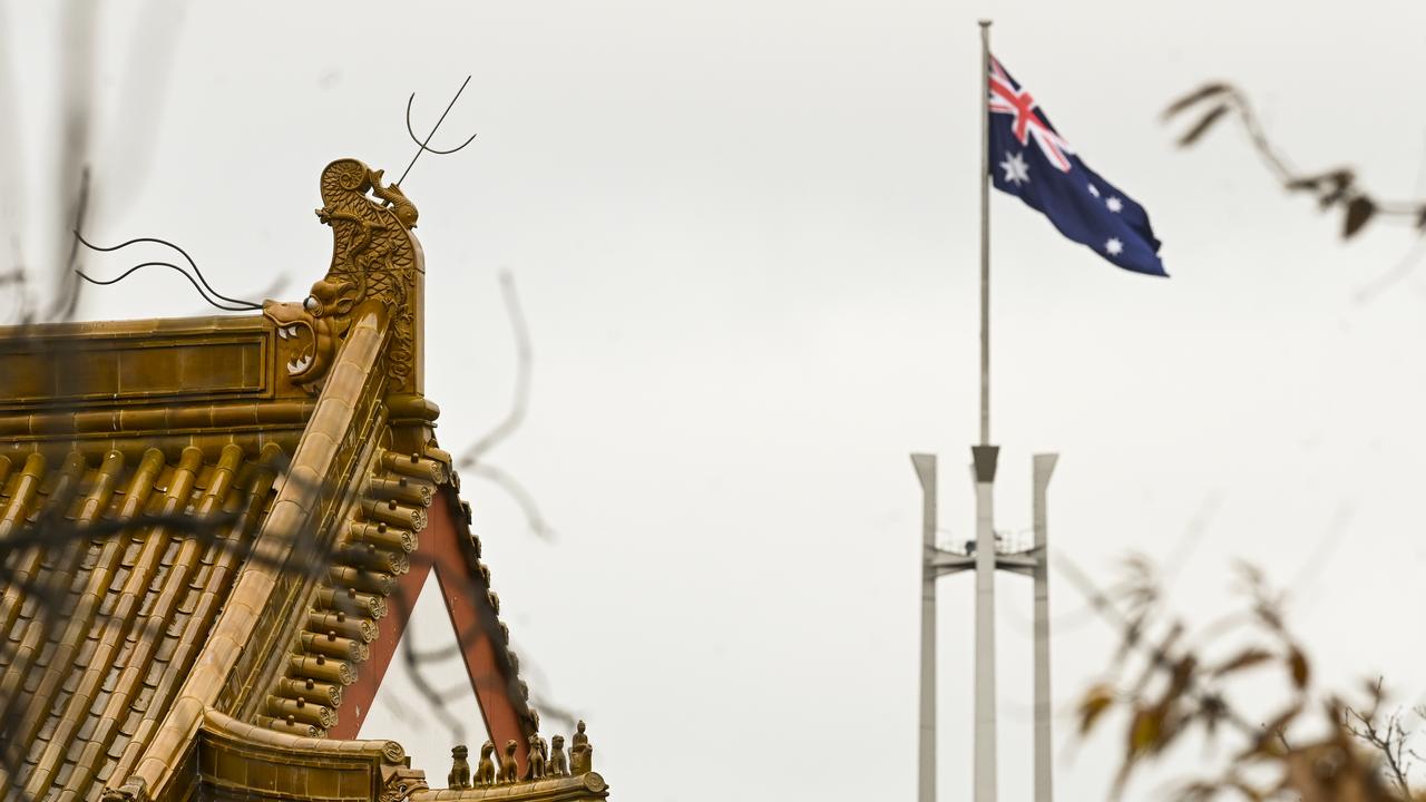 The flag pole of the Australian parliament is seen behind the roofs of the Chinese Embassy in Canberra. Picture: AAP Image/Lukas Coch.