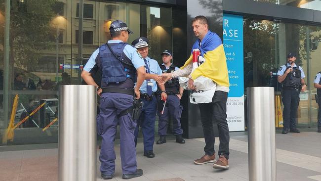 Anton Bogdanovych speaks to police outside the German embassy.