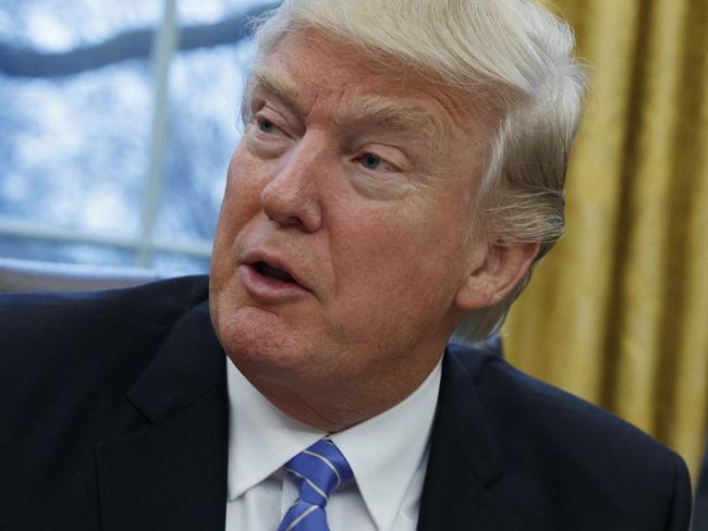 President Donald Trump signs an executive order to withdraw the U.S. from the 12-nation Trans-Pacific Partnership trade pact agreed to under the Obama administration, Monday, Jan. 23, 2017, in the Oval Office of the White House in Washington. (AP Photo/Evan Vucci)