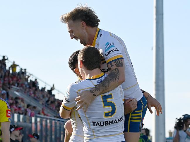 SUNSHINE COAST, AUSTRALIA - JUNE 24: Will Penisini of the Eels is congratulated by team mates Sean Russell and Bryce Cartwright of the Eels after scoring a try during the round 17 NRL match between the Dolphins and Parramatta Eels at Sunshine Coast Stadium on June 24, 2023 in Sunshine Coast, Australia. (Photo by Bradley Kanaris/Getty Images)