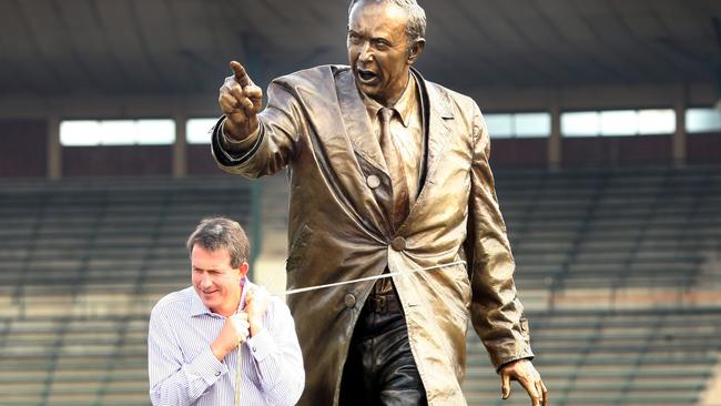 Former Hawthorn CEO Ian Robson puts the statue of John Kennedy into place.