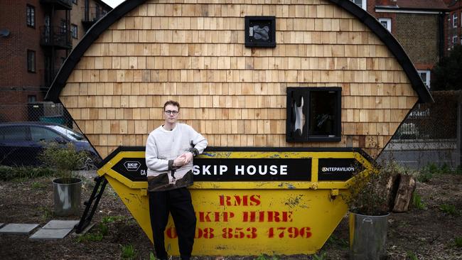 Harrison Marshall poses outside the skip which he has converted into a home in London. Picture: Reuters