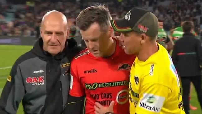 Panthers trainer Pete Green (C) being escorted from the field by Penrith officials.