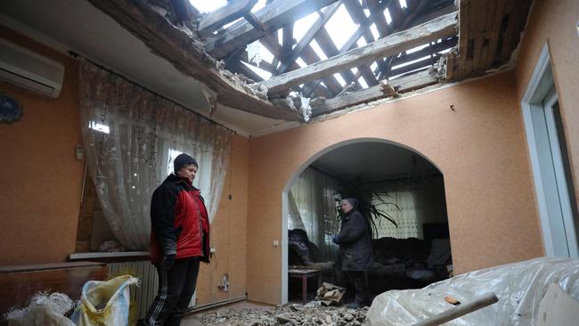 Residents of the Ukrainian-controlled village of Stanytsia Luhanska, Luhansk region, clean up debris from their home after the shelling by Russia-Backed separatists. Picture: AFP