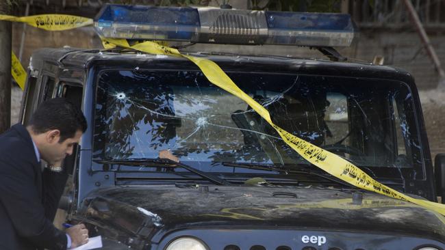 An Egyptian explosives expert takes note of a damage to a police vehicle following a bomb explosion in Cairo, Egypt. Picture: AP