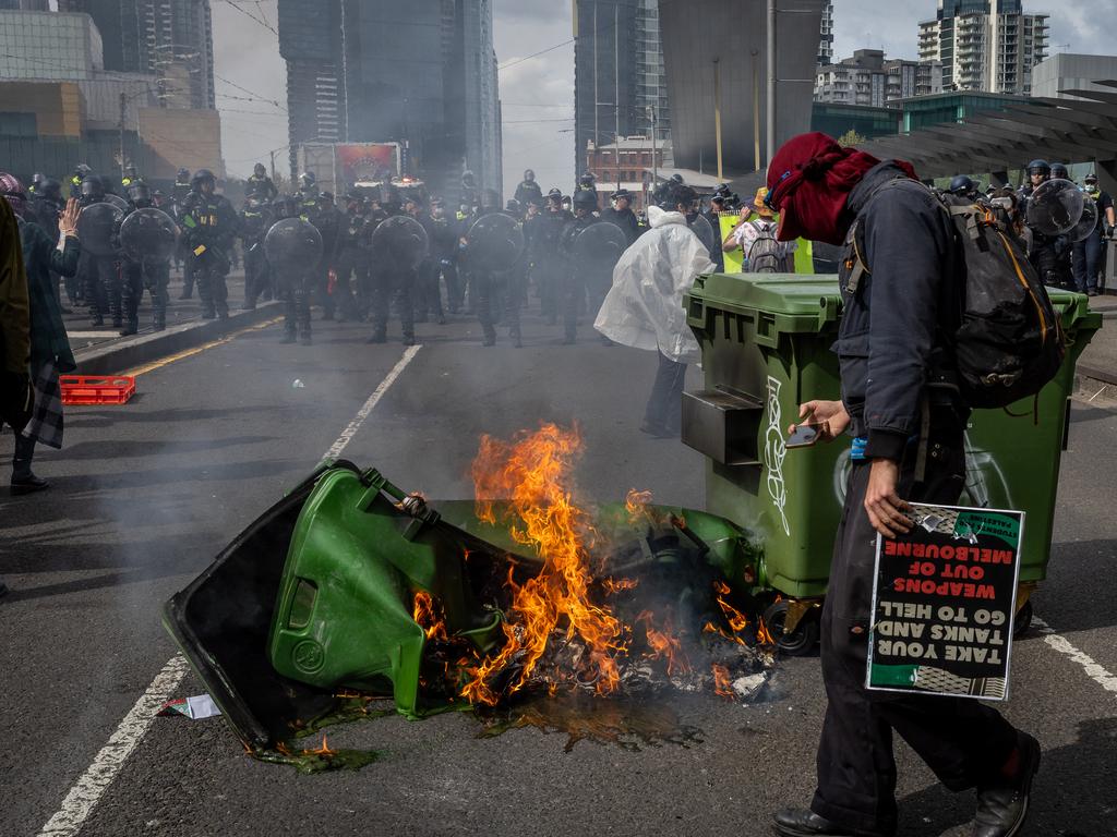 Anti-war activists set bins on fire among other acts at the Land Forces expo. Picture: Jake Nowakowski