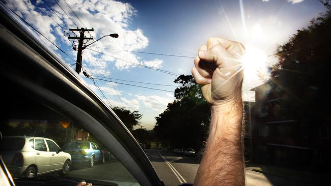 Generic pic of a motorist inside his car as he shakes his fist at passing vehicles.