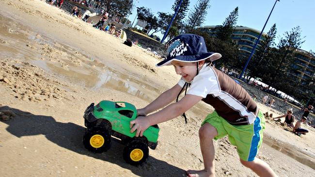 Henry Preston pushes his truck along some water canals on the beach.