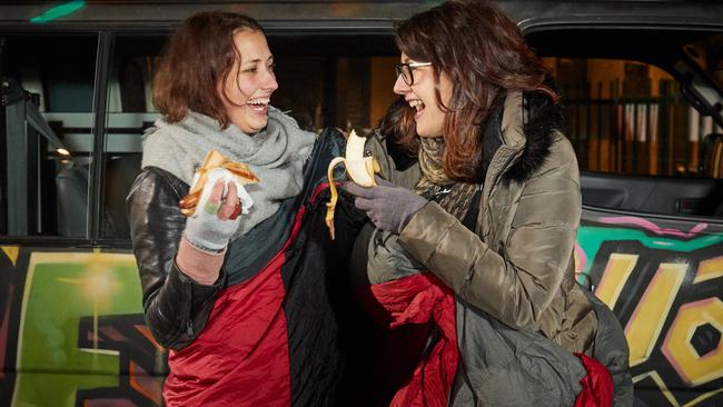 News Corp’s Nadja Fleet and Sandra Ogden finish their last meal (a sausage) before the Vinnies CEO sleepout. Picture: AAP / Matt Loxton