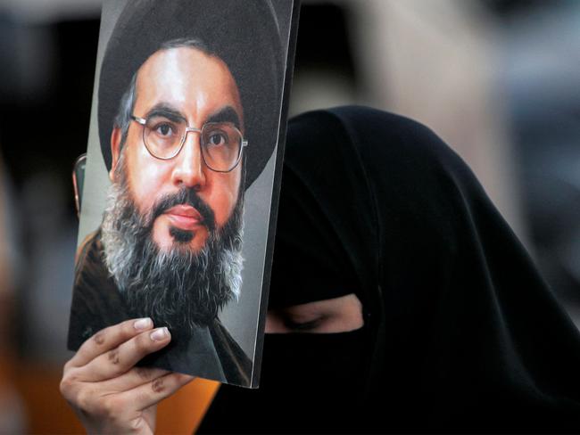 A woman holds up a painting of Hassan Nasrallah, the late leader of the Lebanese Shiite group Hezbollah who was killed in an Israeli air strike in Beirut. Picture: AFP