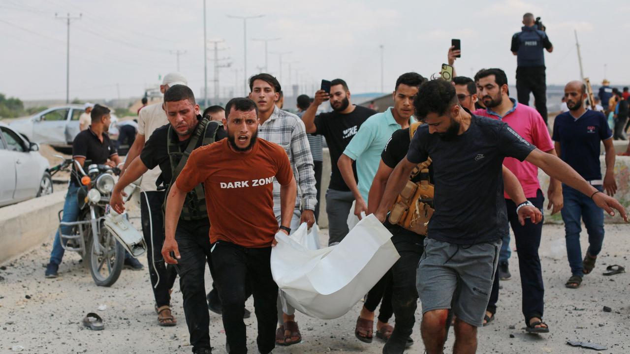 Palestinian men carry a victim following an Israeli air strike at the Erez crossing between Israel and the northern Gaza Strip. Picture: AFP