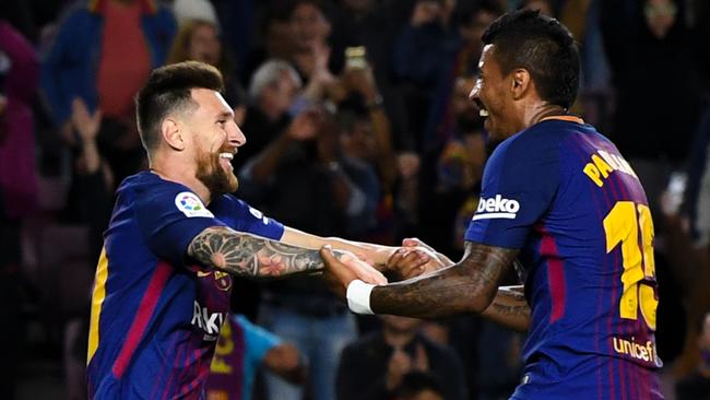 Lionel Messi of FC Barcelona celebrates with his team mate Paulinho.