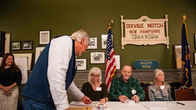 A resident of Dixville Notch shows their ID as they check in to cast their ballots in the US election at midnight in the living room of the Tillotson House at the Balsams Grand Resort. Picture: Joseph Prezioso/AFP