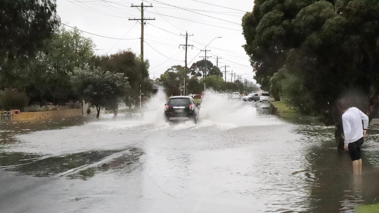 Motorists drive through floodwater at the intersection of Wilsons Rd and Dew St, Whittington. Police had closed parts of Wilsons Rd due to flooding on Friday.