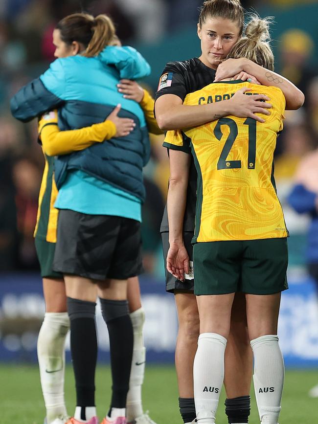 Australia players embrace after the team's 1-3 defeat and elimination from the tournament. Picture: Brendon Thorne/Getty Images