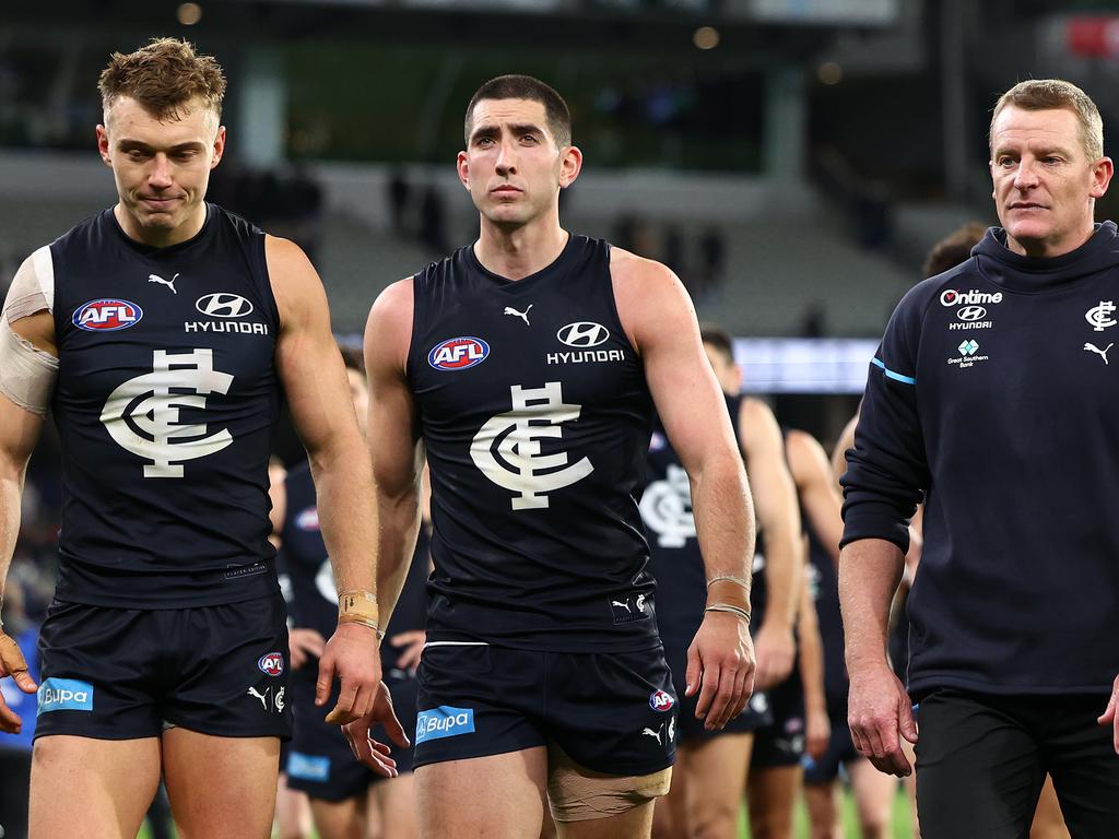 MELBOURNE, AUSTRALIA - MAY 03: Patrick Cripps, Jacob Weitering and Michael Voss, Senior Coach of the Blues look dejected after losing the round eight AFL match between Carlton Blues and Collingwood Magpies at Melbourne Cricket Ground, on May 03, 2024, in Melbourne, Australia. (Photo by Quinn Rooney/Getty Images)