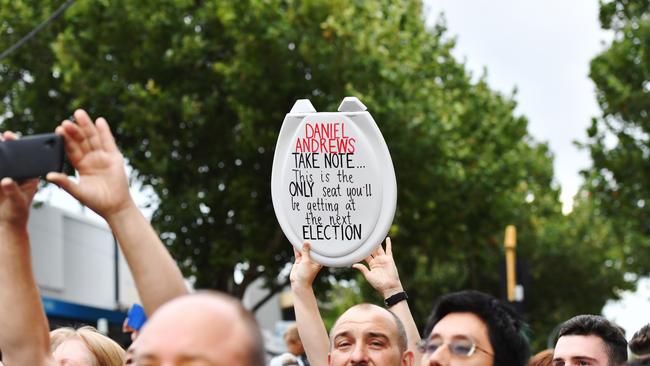 A protester holds up a toiled seat. Picture: Jake Nowakowski