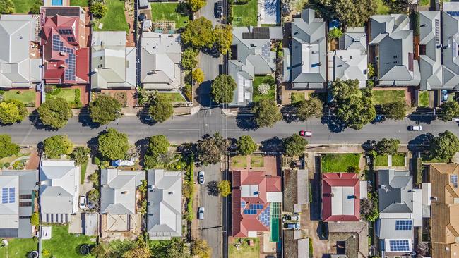 Aerial view of leafy eastern suburban houses in 2 rows on 4-way cross road intersection in Adelaide, South Australia: directly above, rooftop solar, front & backyard, play equipment, variety of roofing materials and colours; motor vehicles; 16x9 format