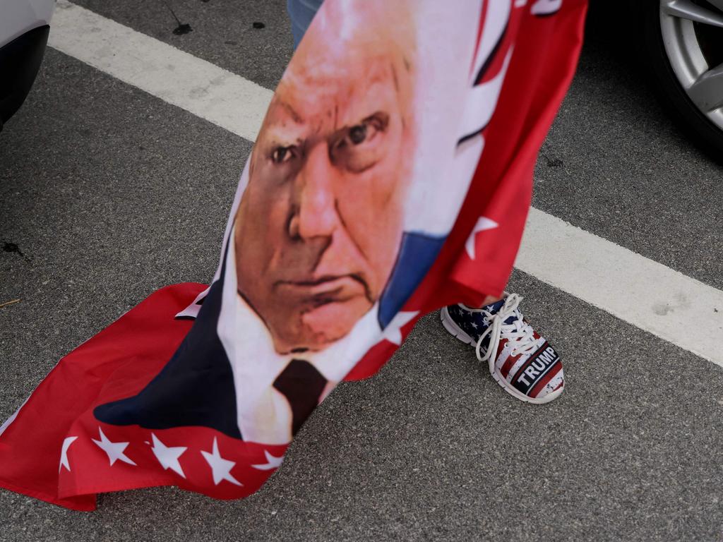 This supporter with Trump sneakers and flag supporters was one of a number of Trump voters who turned up near Mar-a-Lago in Palm Beach, Florida, after Trump became the first former US president to be convicted of felony crimes. Picture: Alon Skuy/Getty Images/AFP