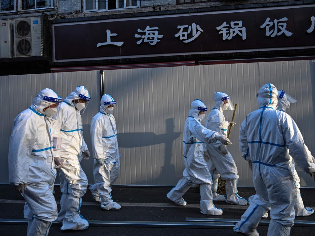 Health workers in an area where barriers are being placed to close off streets around some lockdown areas after the detection of new cases of Covid in Shanghai. Picture: AFP