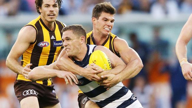 Jaeger O'Meara tackles Joel Selwood high.