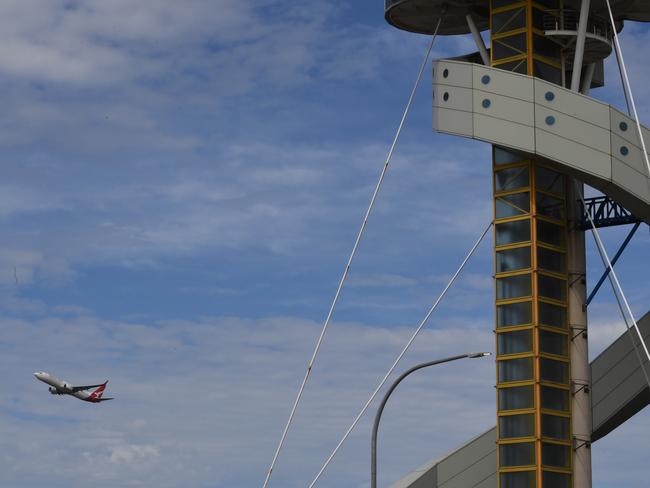 The control tower at Sydney Airport is seen as a plane takes off in Sydney, Friday, March 29, 2019. Flights are slowly resuming after Sydney Airport's air traffic control tower was evacuated after smoke was detected inside. (AAP Image/Peter Rae) NO ARCHIVING