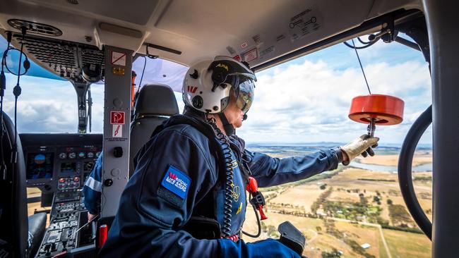 Crew member Wayne Cartwright prepares the winch during flight. Picture: Jake Nowakowski