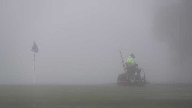 Worker preparing the greens at the North Adelaide Golf Club in the morning fog, July 14. Picture: Tait Schmaal