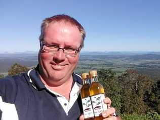 TUFFLES TRAVEL: Matt Hibberd with some truffle oil at a lookout en route to Mt Tambourine where he is officially opening another shop on Sunday. Picture: Contributed