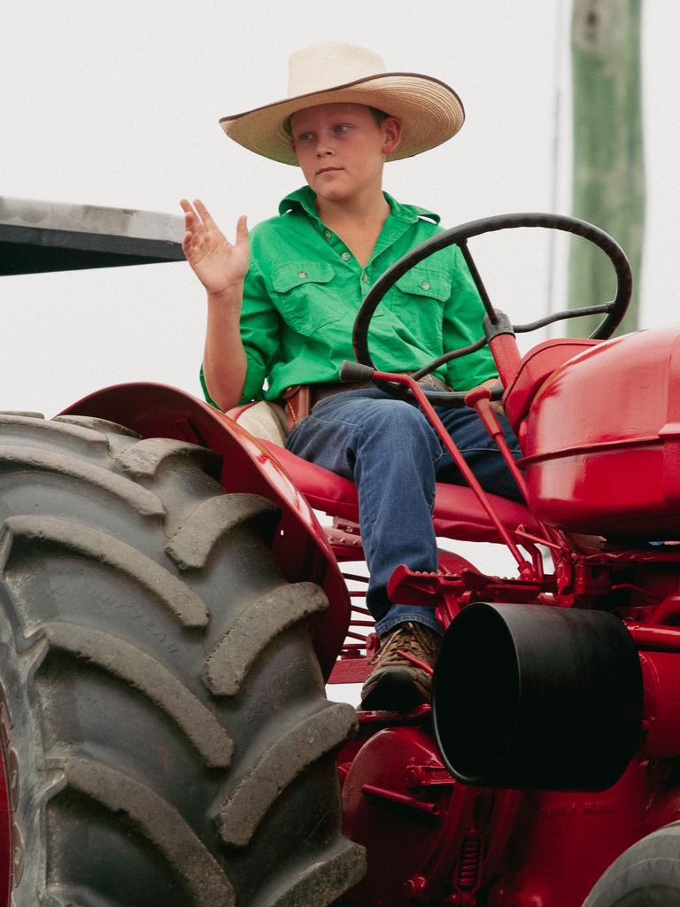 A young farmer waves to the crowd at the 2023 Gayndah Orange Festival.