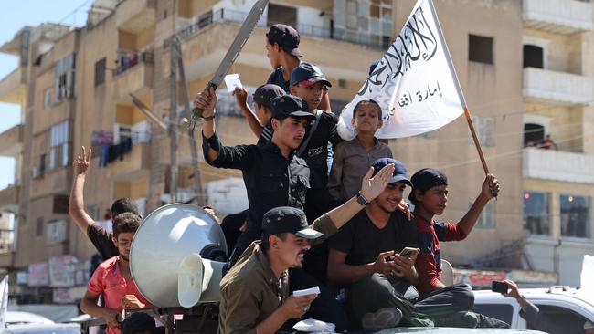 Members of Syria's top jihadist group the Hayat Tahrir al-Sham (HTS) alliance, led by al-Qaeda's former Syria affiliate, parade with their flags and those of the Taliban's declared "Islamic Emirate of Afghanistan" last week. Picture: AFP