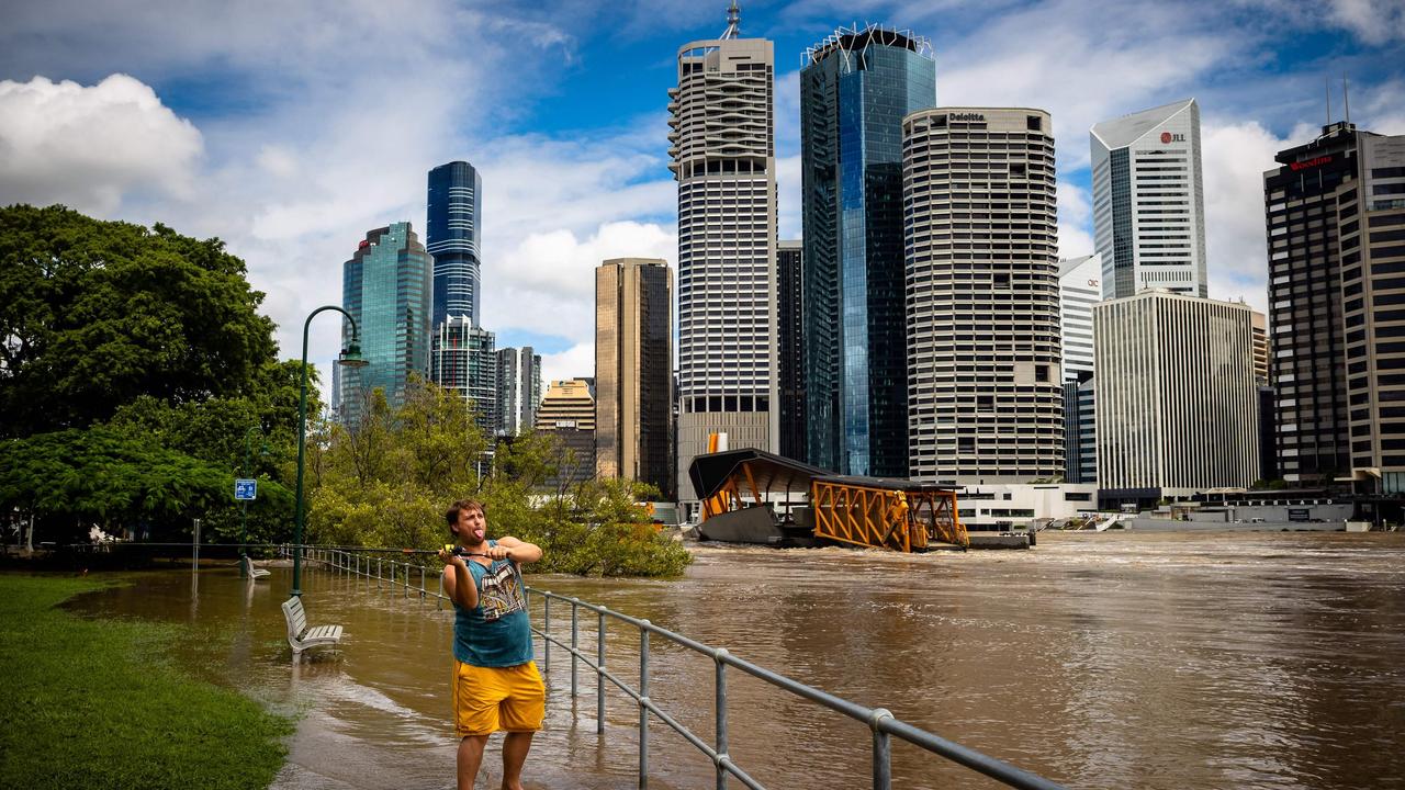 A man casts a fishing line into the swollen Brisbane River in Brisbane on February 28, 2022, following heavy rains and nearby flooding. Picture: AFP