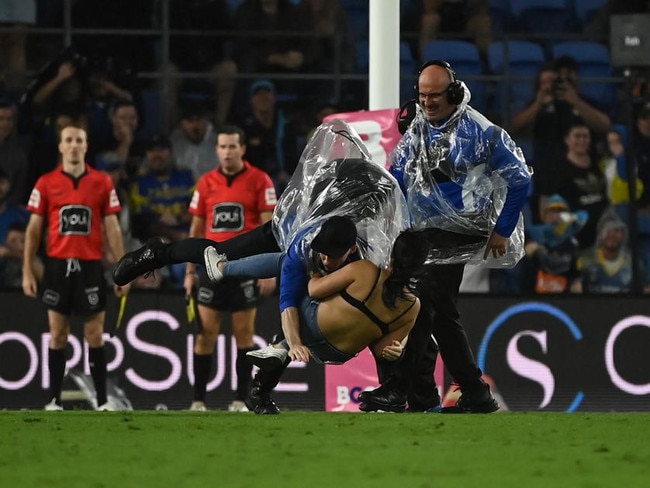 Streaker, Javon Johanson, gets tackled by security on the Gold Coast. NRL Imagery