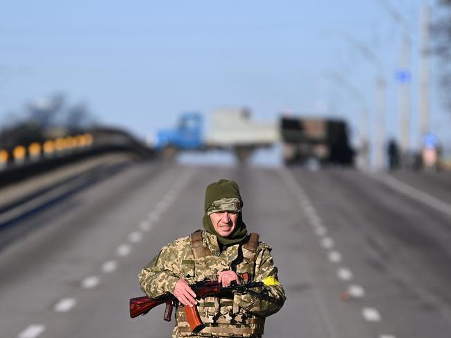 A Ukrainian service member patrols the empty road on west side of the Ukrainian capital of Kyiv. Picture: AFP