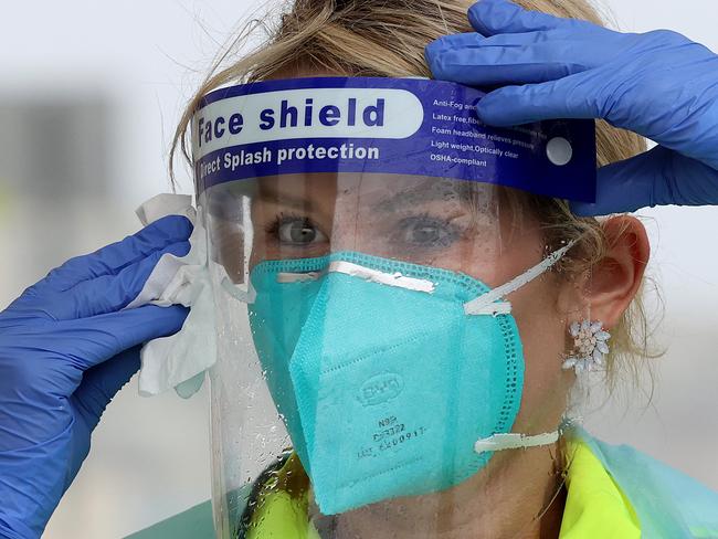 SYDNEY, AUSTRALIA - NewsWire Photos October 25, 2020: Pictured: Wearing rain gear is Registered Nurse Francee Drew wiping the rain off of her face shield at St VincentÃs Hospital Bondi Beach Covid testing site in Sydney, NSW. Picture: NCA NewsWire / Dylan Coker