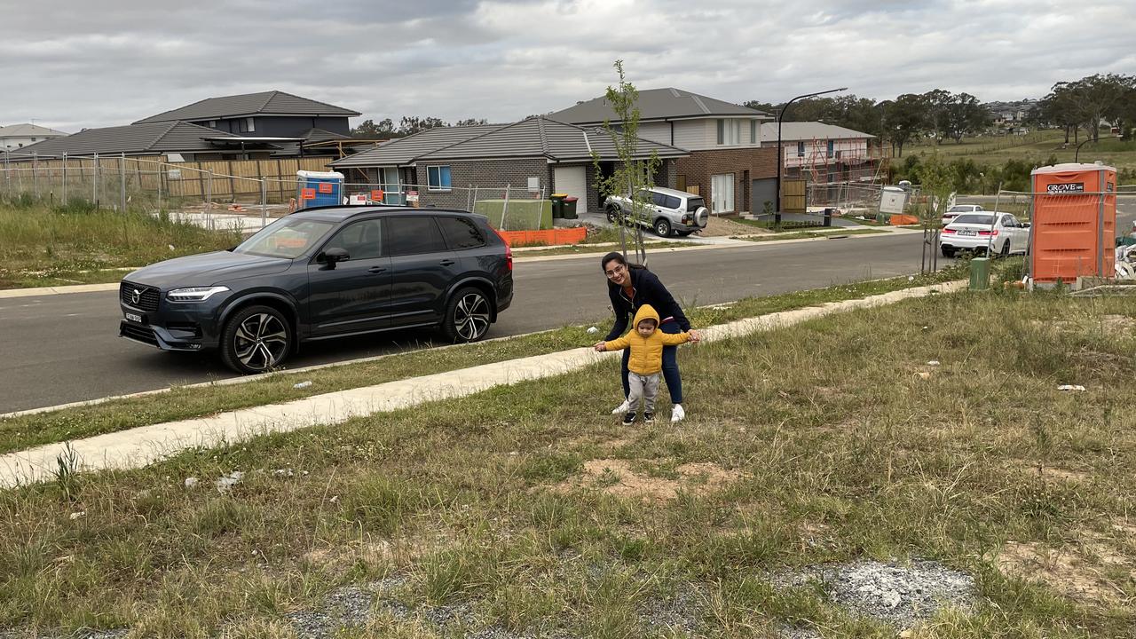 Ms Nabi and her son on their empty site where a house should stand.