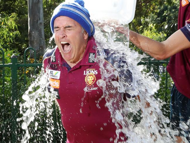 Lions AFL coach Chris Fagan in beanie (for motor neurone disease charity) being dunked with a bucket of ice water by Lions player Eric Hipwood, Bulimba. Photographer: Liam Kidston.