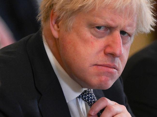 (FILES) In this file photo taken on May 24, 2022 Britain's then prime minister Boris Johnson adjusts his tie at the start of a cabinet meeting at 10 Downing Street in London. Johnson announced his resignation as an MP on June 9, 2023, accusing a parliamentary probe into the "Partygate" scandal of driving him out. Johnson, 58, said he was stepping down with immediate effect "triggering an immediate by-election" in his marginal seat, which heaps political pressure on his successor Rishi Sunak. (Photo by Daniel LEAL / POOL / AFP)