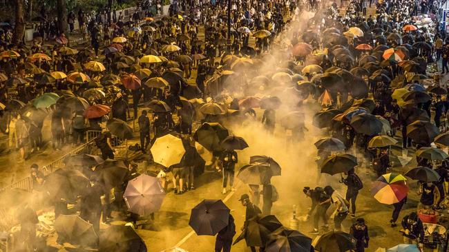 Protesters run from a cloud of tear gas at Hong Kong Polytechnic University. Picture: AFP