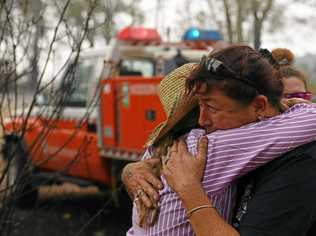 Bora Ridge resident Clare Barry embraces Rural Fire Fighter Raelene Davis after Raelene and her daughter Chantelle helped save the property and horses. Picture: Marc Stapelberg